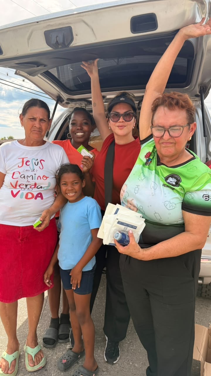 Familia recibiendo medicinas y apoyo de las voluntarias
